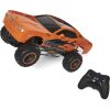 Orange toy car next to remote control, pointing to the left corner